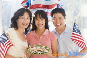 1family-outdoors-on-fourth-of-july-with-flags-and-cookies-smiling
